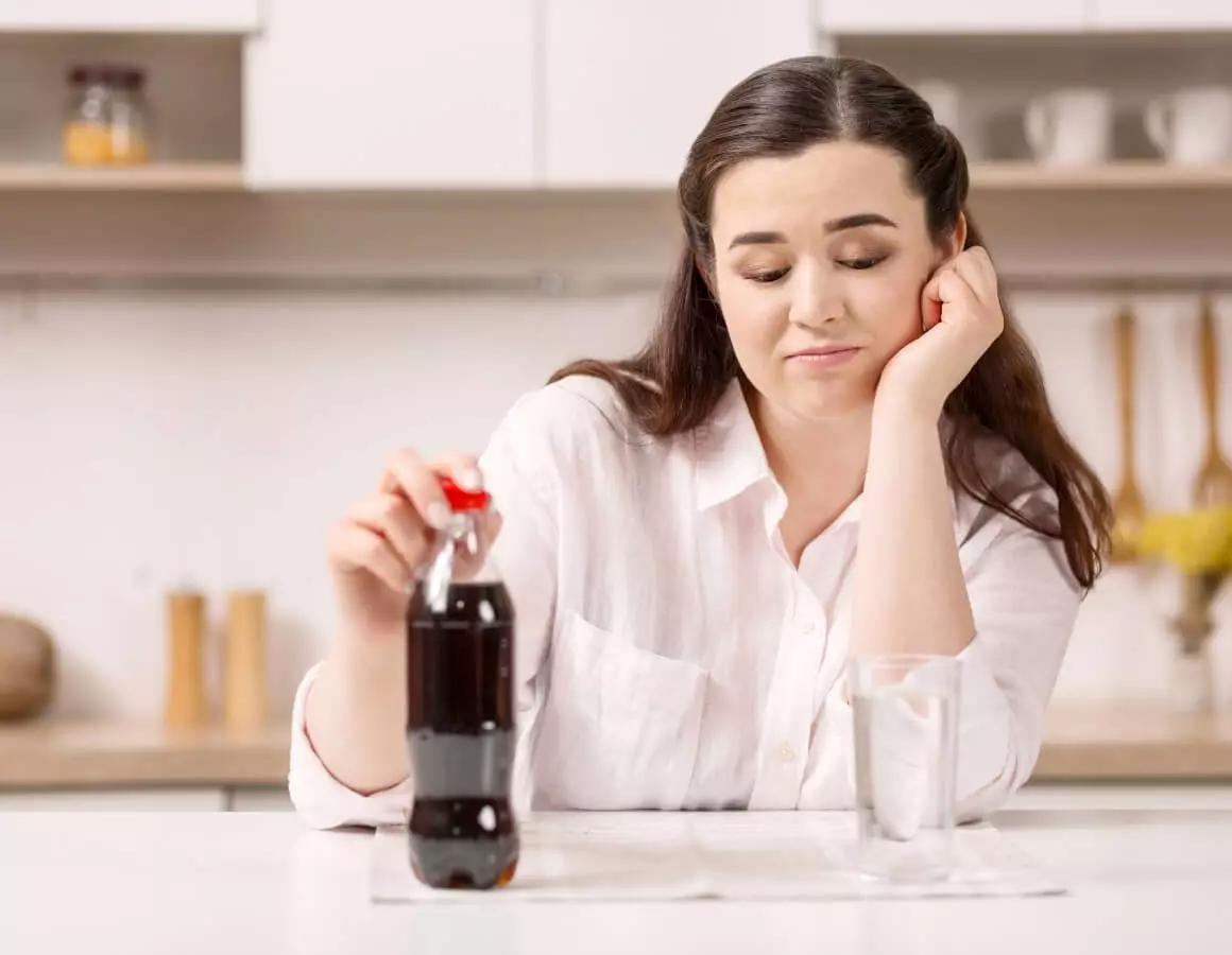 woman choosing between soda and water